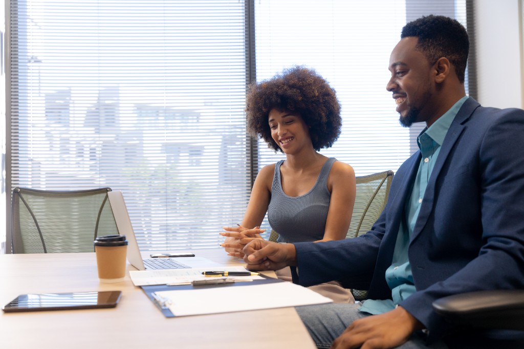 Two colleagues talking through a plan in a boardroom